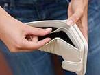 42-15763170 - Young Woman Looking Through Wallet